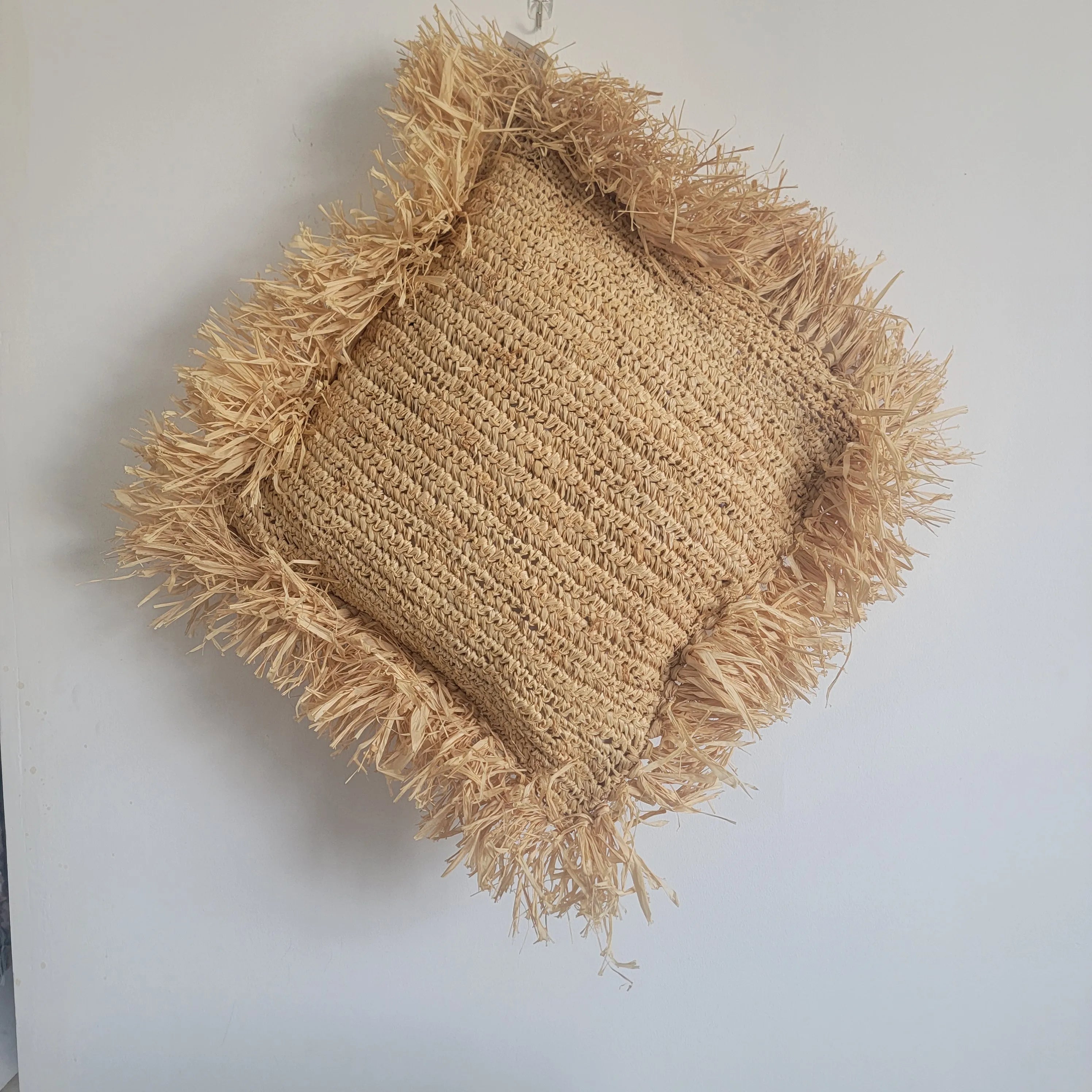 Coussin décoratif en raphia tressé avec franges