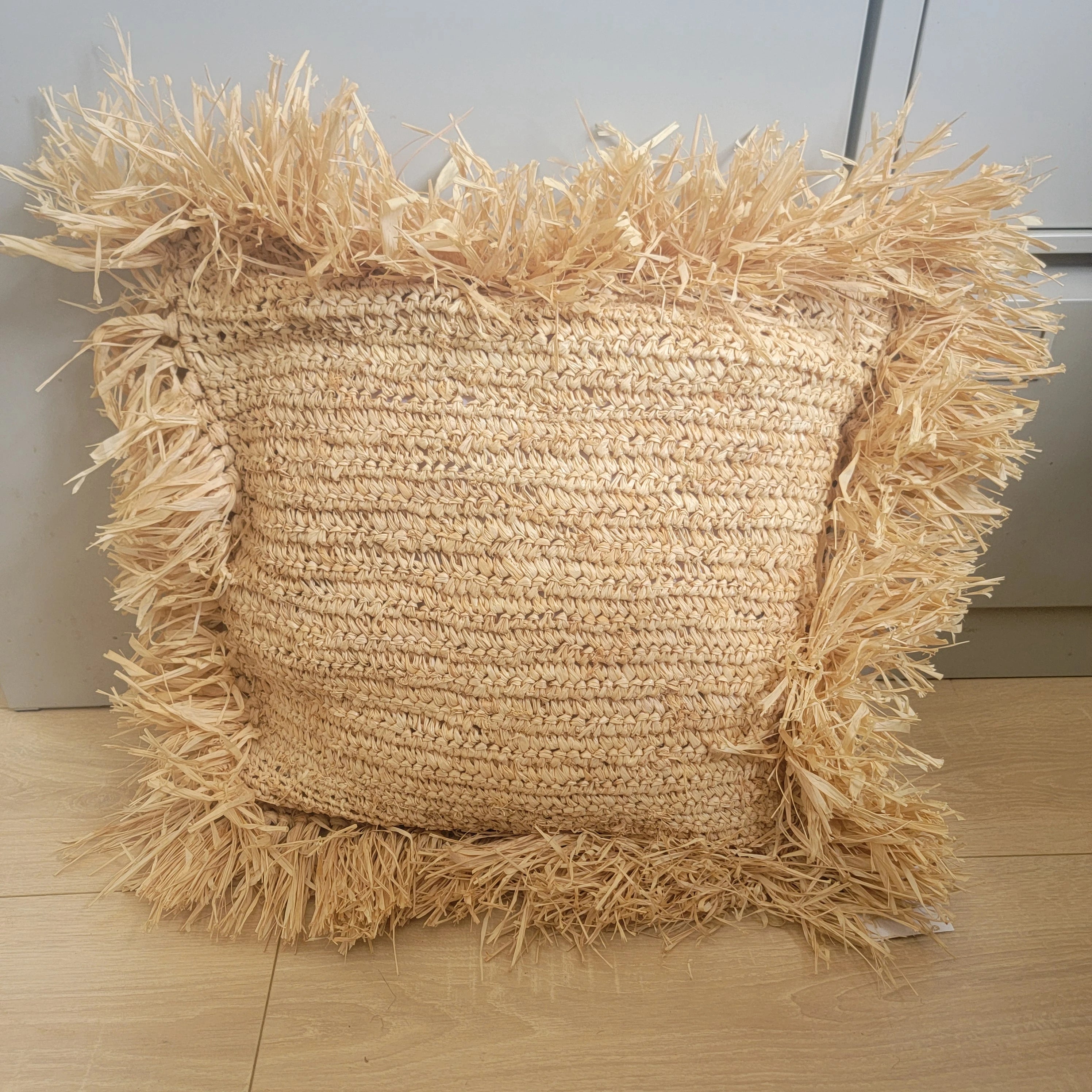 Coussin décoratif en raphia tressé avec franges