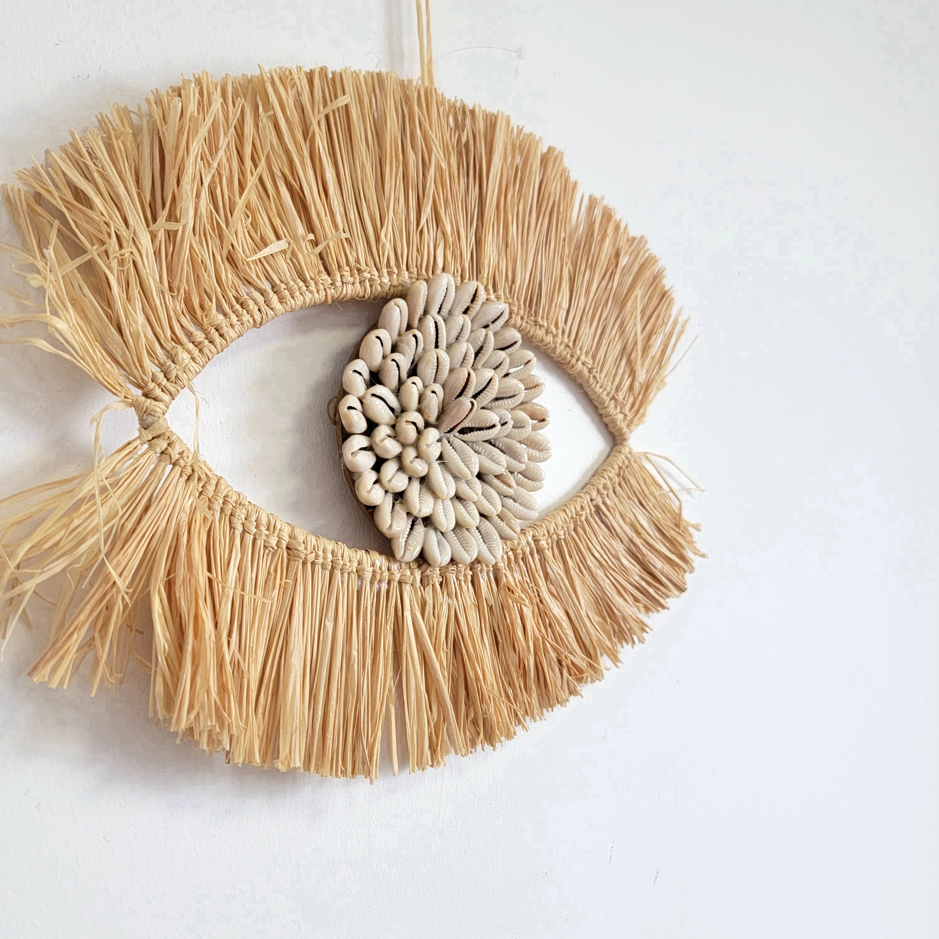 Décoration murale œil en raphia et coquillages naturels